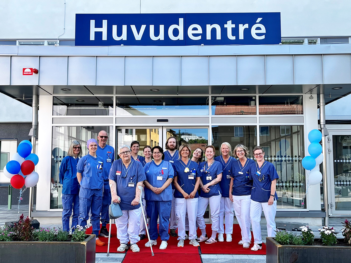 Glad personal ståendes framför den nya huvudentrén