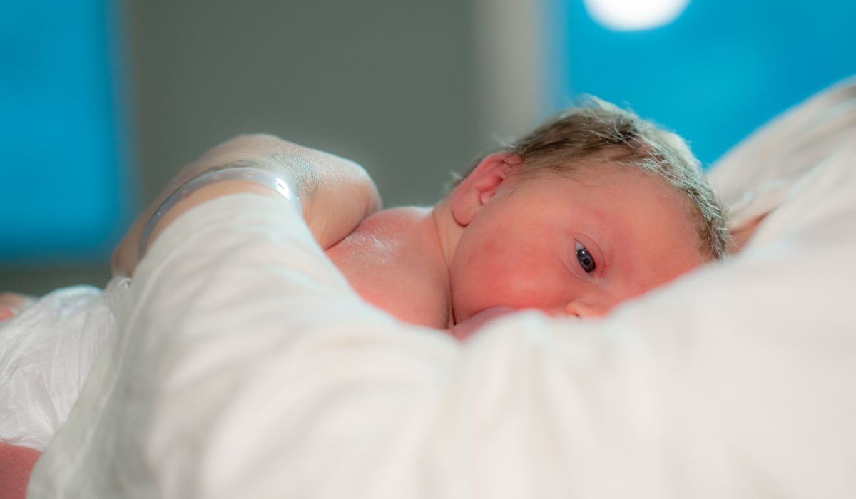 En trött liten bebis som ligger på sin pappas bröst. 