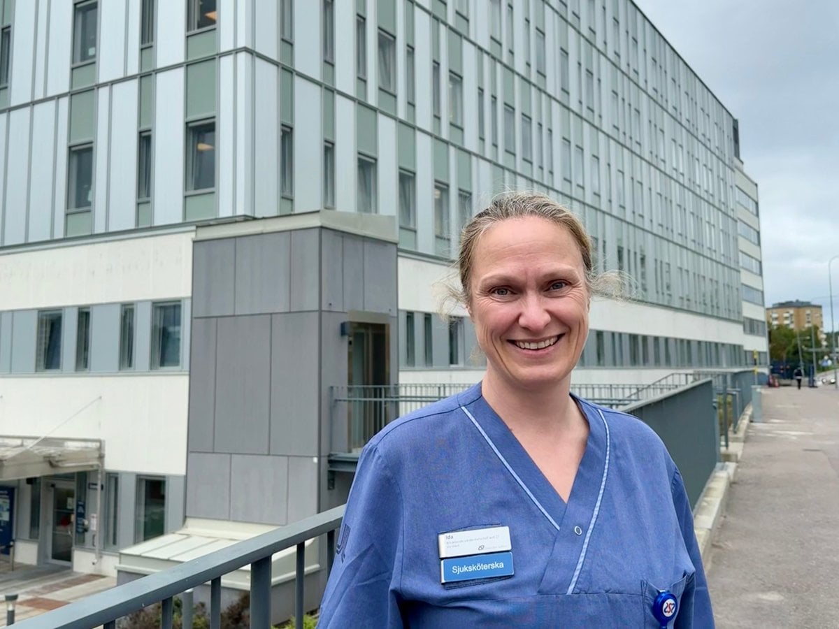 Sjuksköterska framför sjukhusbyggnad