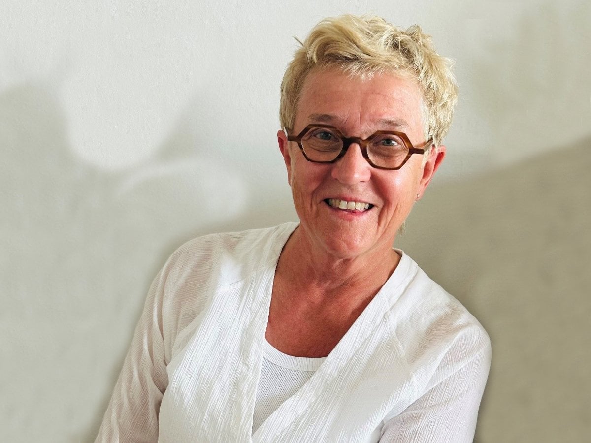 Glad kvinna i vita kläder.