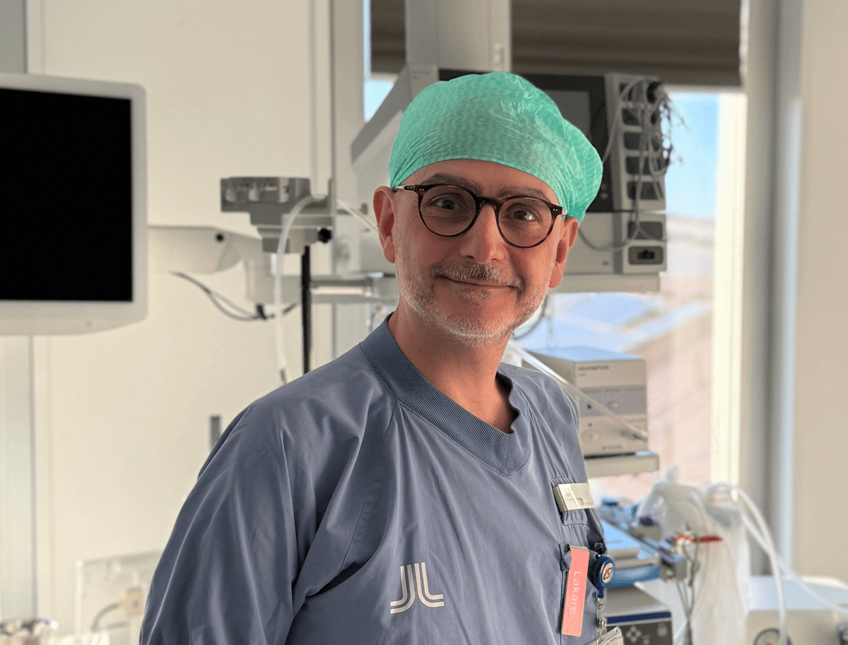 En man i operationskläder står i ett sjukhusrum.