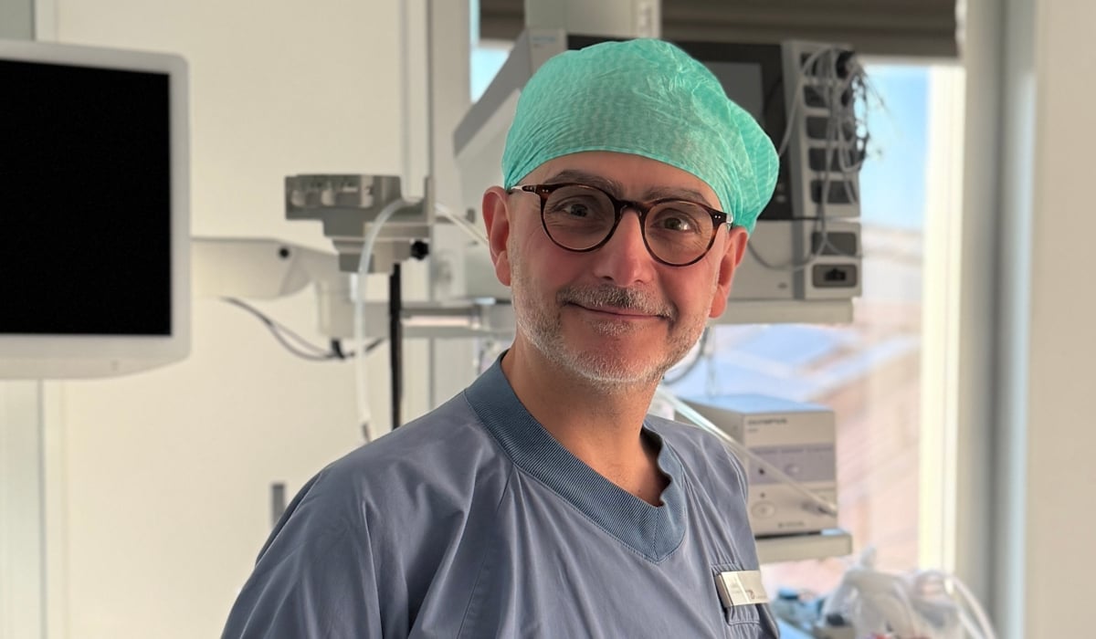 En man i operationskläder står i ett sjukhusrum.