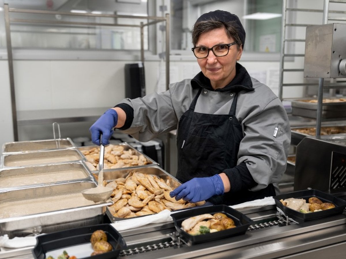 En person i ett kök som förbereder mat.