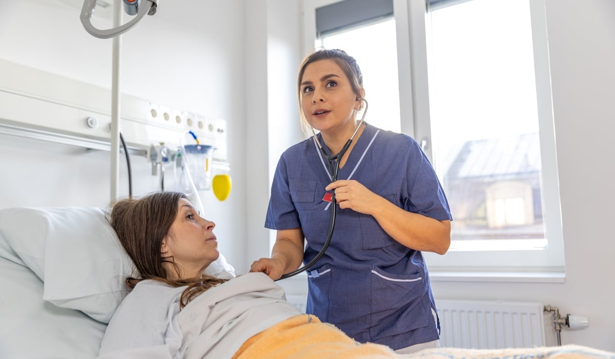 Läkare lyssnar på patients hjärta med stetoskop