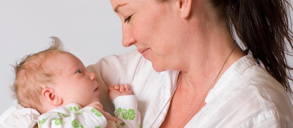 En kvinna som håller i en bebis