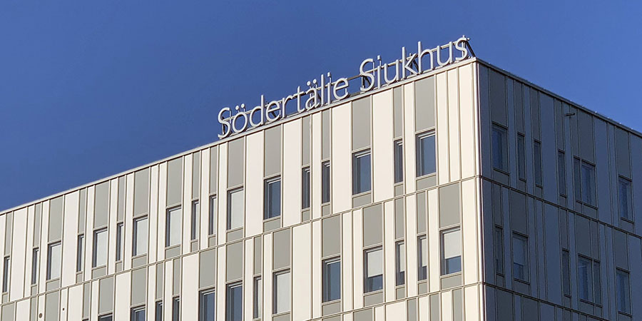 Södertälje sjukhus Hus 19 fasadbild med logotyp och blå himmel