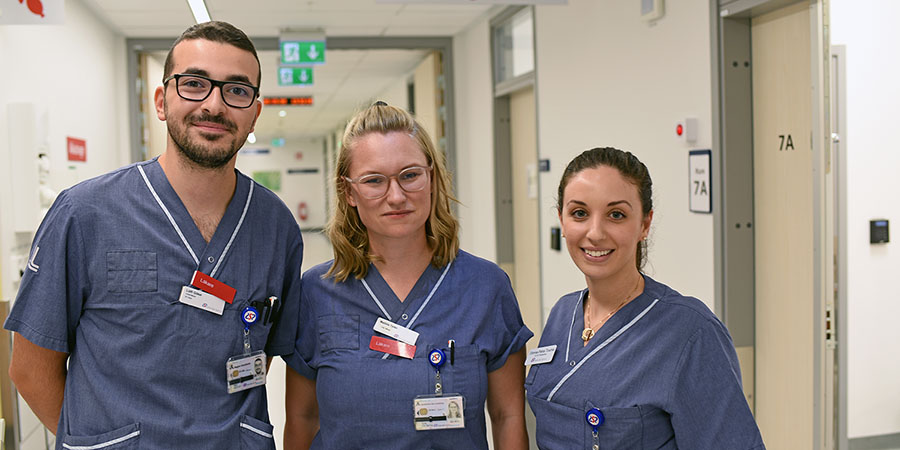 Tre medarbetare står i sjukhuskorridor